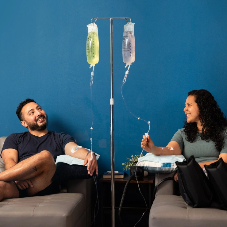 Young couple relaxing while enjoying a vitamin IV Drip from Restore Hyper Wellness